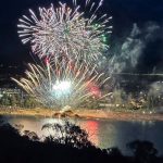 Fireworks display over a lake at night